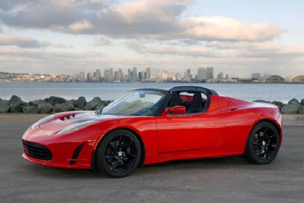 Tesla Roadster สีแดงวิ่งบนท้องถนนรีมทะเล