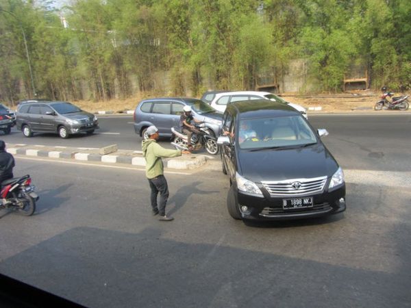 การช่วยโบกรถแลกเงินในช่วงที่รถติดมากๆของประเทศอินโดนีเซีย