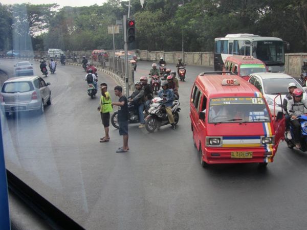 การช่วยโบกรถแลกเงินในช่วงที่รถติดมากๆของประเทศอินโดนีเซีย